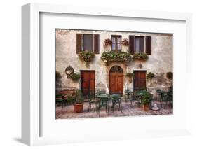 Italy, Tuscany, Pienza. Tables and chairs set up outside for outdoor dining in the town of Pienza.-Julie Eggers-Framed Photographic Print