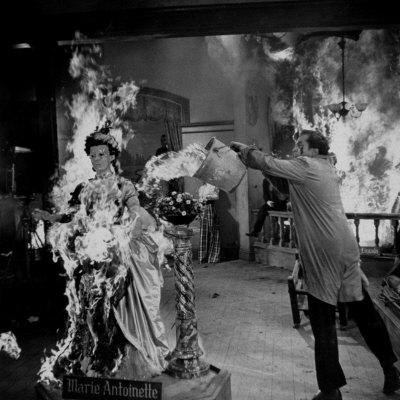 Actor Vincent Price Putting Out Fire in Film "House of Wax"