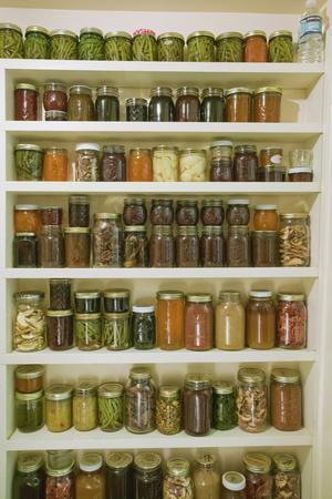 Pantry of preserved fruits and vegetables in canning jars. (PR)