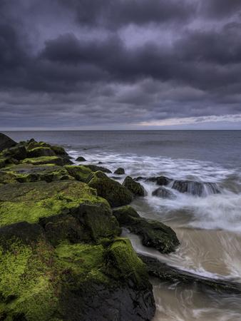 USA, New Jersey, Cape May National Seashore. Storm waves crash on rocks.