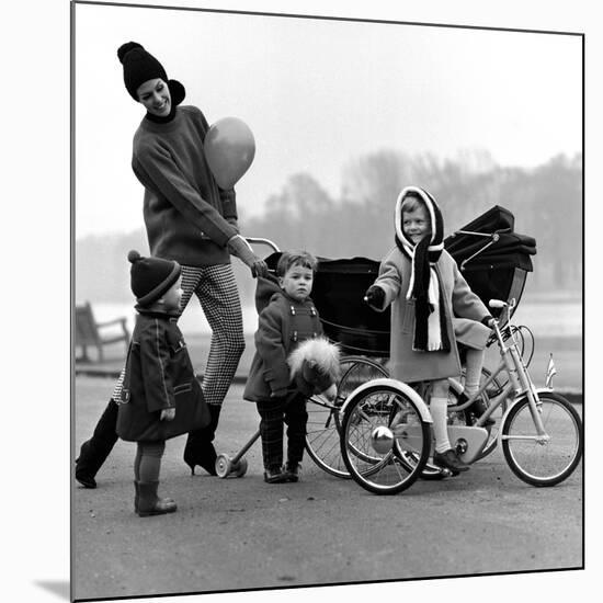 Jenny Boyd in Light Pants and Boots with Children, 1960s-John French-Mounted Giclee Print