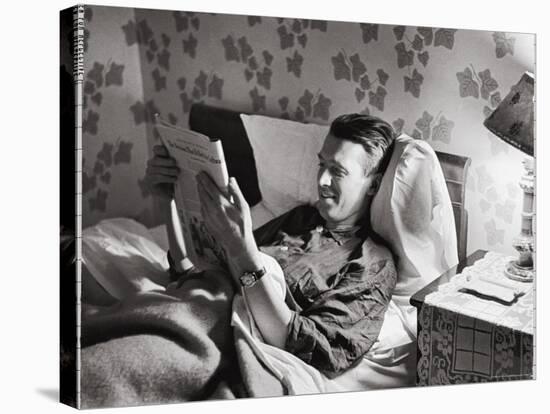 Jimmy Stewart, Dressed in Silk Pajamas Reading Magazine in Bed in Family Home-Peter Stackpole-Stretched Canvas