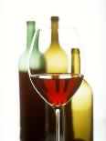 Glass of Red Wine in Front of Three Wine Bottles-Joerg Lehmann-Photographic Print