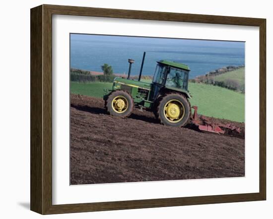 John Deere Tractor with a Rotivator on a Sloping Field in Spring, at Holcombe, Devon, England, UK-Ian Griffiths-Framed Photographic Print