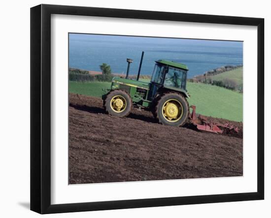 John Deere Tractor with a Rotivator on a Sloping Field in Spring, at Holcombe, Devon, England, UK-Ian Griffiths-Framed Photographic Print