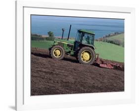 John Deere Tractor with a Rotivator on a Sloping Field in Spring, at Holcombe, Devon, England, UK-Ian Griffiths-Framed Photographic Print