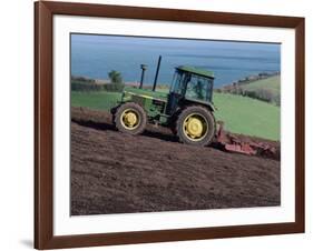 John Deere Tractor with a Rotivator on a Sloping Field in Spring, at Holcombe, Devon, England, UK-Ian Griffiths-Framed Photographic Print