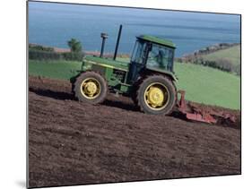 John Deere Tractor with a Rotivator on a Sloping Field in Spring, at Holcombe, Devon, England, UK-Ian Griffiths-Mounted Photographic Print