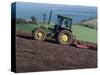 John Deere Tractor with a Rotivator on a Sloping Field in Spring, at Holcombe, Devon, England, UK-Ian Griffiths-Stretched Canvas