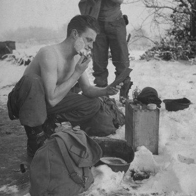 GI shaving with mirror during ull in the Ardennes Forest Conflict called the Battle of the Bulge