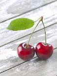 A Pair of Cherries with a Leaf on a Wooden Table-Jürgen Klemme-Photographic Print