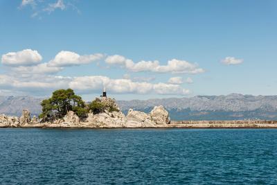 Rocks the Harbour Wall and a Statue of the Madonna in the Harbour at Trpanj Croatia