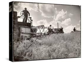 Kansas Farmer Driving Farmall Tractor as He Pulls a Manned Combine During Wheat Harvest-Margaret Bourke-White-Stretched Canvas