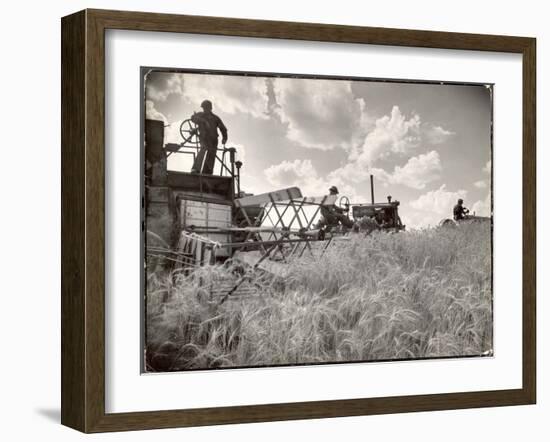 Kansas Farmer Driving Farmall Tractor as He Pulls a Manned Combine During Wheat Harvest-Margaret Bourke-White-Framed Photographic Print