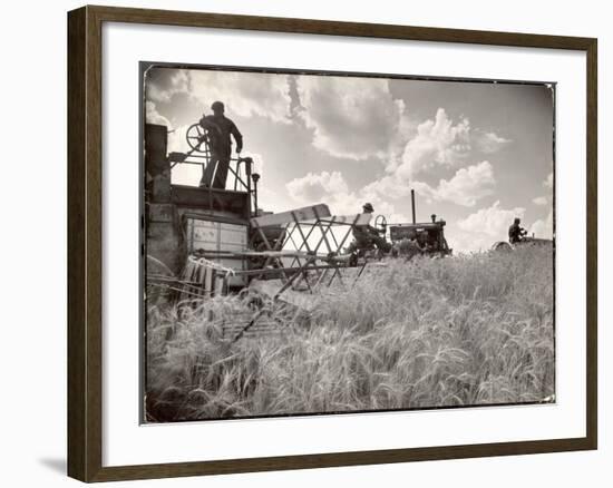 Kansas Farmer Driving Farmall Tractor as He Pulls a Manned Combine During Wheat Harvest-Margaret Bourke-White-Framed Photographic Print