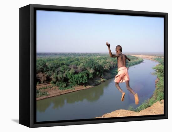 Karo Boy Leaps Off a Cliff Over the Omo River, Ethiopia-Janis Miglavs-Framed Stretched Canvas