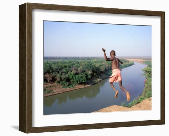 Karo Boy Leaps Off a Cliff Over the Omo River, Ethiopia-Janis Miglavs-Framed Premium Photographic Print