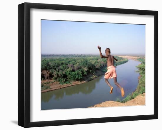 Karo Boy Leaps Off a Cliff Over the Omo River, Ethiopia-Janis Miglavs-Framed Premium Photographic Print