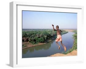 Karo Boy Leaps Off a Cliff Over the Omo River, Ethiopia-Janis Miglavs-Framed Premium Photographic Print