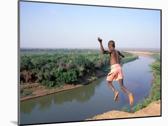 Karo Boy Leaps Off a Cliff Over the Omo River, Ethiopia-Janis Miglavs-Mounted Premium Photographic Print