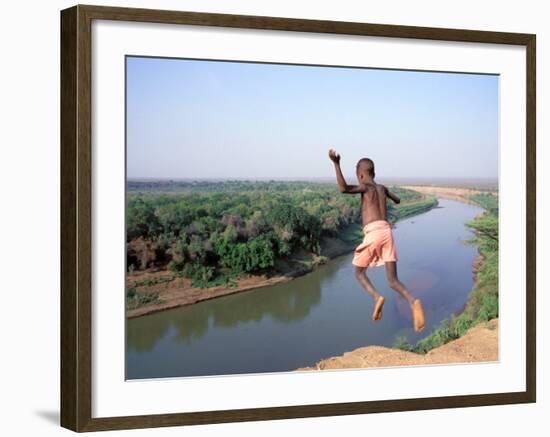 Karo Boy Leaps Off a Cliff Over the Omo River, Ethiopia-Janis Miglavs-Framed Photographic Print