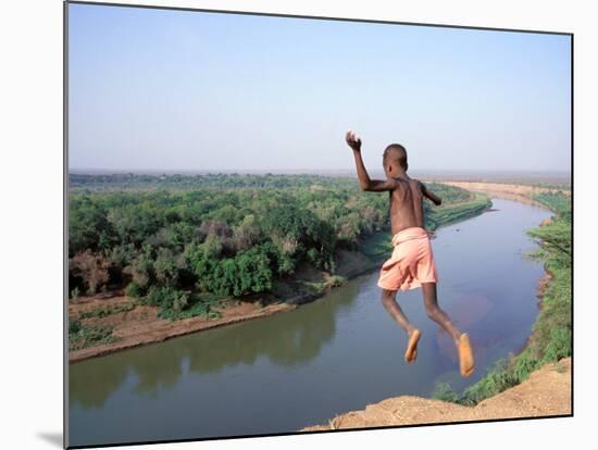 Karo Boy Leaps Off a Cliff Over the Omo River, Ethiopia-Janis Miglavs-Mounted Photographic Print