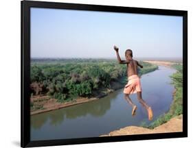Karo Boy Leaps Off a Cliff Over the Omo River, Ethiopia-Janis Miglavs-Framed Photographic Print