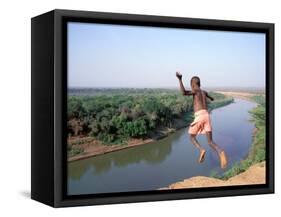 Karo Boy Leaps Off a Cliff Over the Omo River, Ethiopia-Janis Miglavs-Framed Stretched Canvas