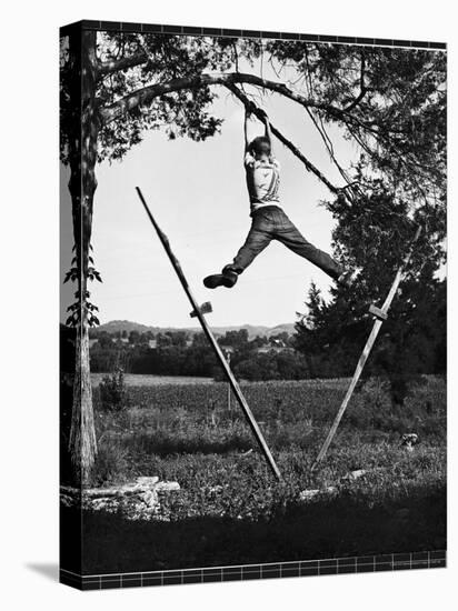 Kenneth Merriman Swinging on Tree Limb After Kicking Away Stilts-Robert W^ Kelley-Stretched Canvas