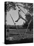 Kenneth Merriman Swinging on Tree Limb after Kicking Away Stilts-null-Stretched Canvas