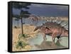 Kentrosaurus Dinosaurs Walking in the Water Next to Sand and Trees-null-Framed Stretched Canvas