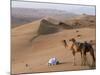 Kneeling to Pray in Desert, Holding Camels by Halters to Prevent Them Wandering Off Amongst Dunes-John Warburton-lee-Mounted Photographic Print