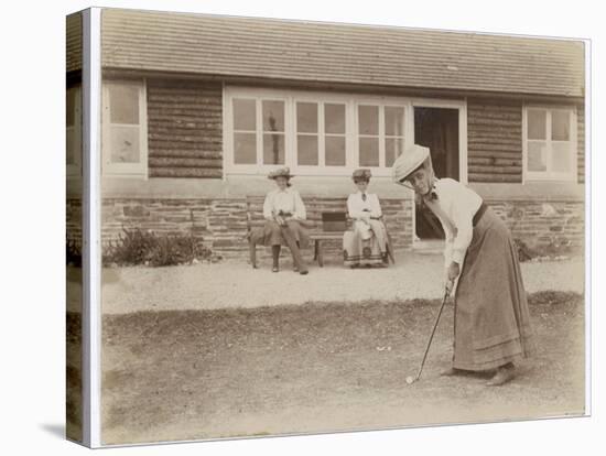 Lady Golfer Prepares to Putt as Two Seated Spectators Watch-null-Stretched Canvas