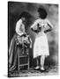 Lady Tries on a Corset While Another Woman Waits with Another One-null-Stretched Canvas