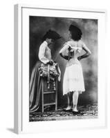 Lady Tries on a Corset While Another Woman Waits with Another One-null-Framed Photographic Print
