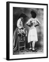 Lady Tries on a Corset While Another Woman Waits with Another One-null-Framed Photographic Print