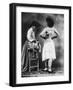 Lady Tries on a Corset While Another Woman Waits with Another One-null-Framed Photographic Print