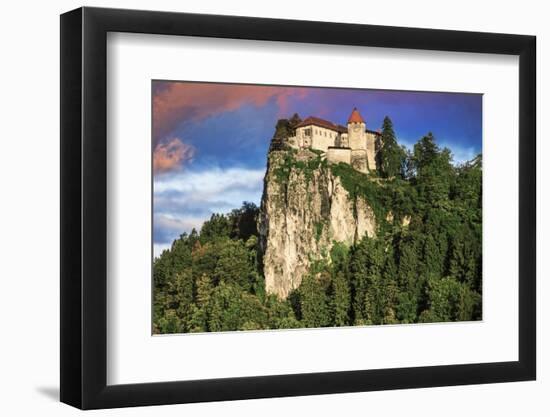 Lake Bled Castle rises on cliffs above Lake Bled, Slovenia at sunset-Miva Stock-Framed Photographic Print