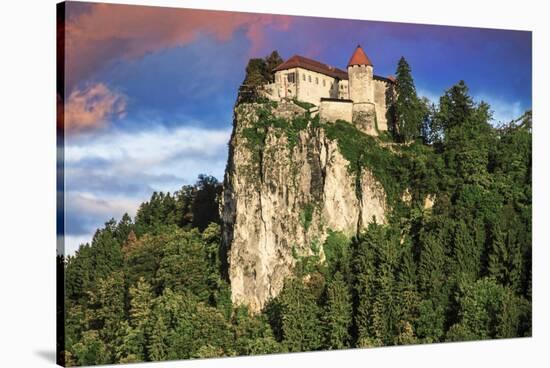 Lake Bled Castle rises on cliffs above Lake Bled, Slovenia at sunset-Miva Stock-Stretched Canvas