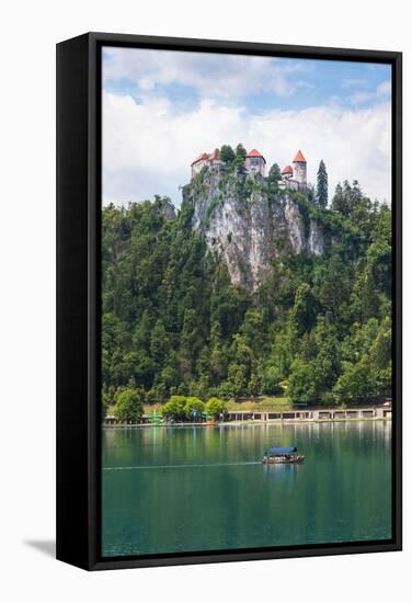 Lake Bled, Upper Carniola, Slovenia. Bled Castle seen across the lake. Tourists enjoying boating...-null-Framed Stretched Canvas