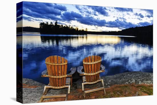 Landscape with Adirondack Chairs on Shore of Relaxing Lake at Sunset in Algonquin Park, Canada-elenathewise-Stretched Canvas