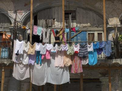 https://imgc.allpostersimages.com/img/posters/large-quantity-of-laundry-hanging-from-the-balcony-of-a-crumbling-building-habana-vieja-cuba_u-L-P1LD7Q0.jpg?artPerspective=n