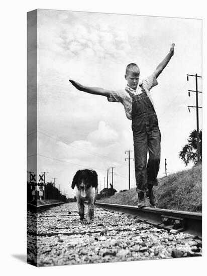 Larry Jim Holm with Dunk, His Spaniel Collie Mix, Walking Rail of Railroad Tracks in Rural Area-Myron Davis-Stretched Canvas