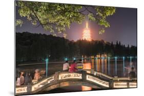 Leifeng Pagoda with Visitors Sitting on Railings of an Illuminated Stone Arch Bridge at West Lake-Andreas Brandl-Mounted Photographic Print