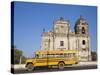 Leon, American Yellow Bluebird Bus Driving Past San Juan Church, Nicaragua-Jane Sweeney-Stretched Canvas