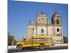 Leon, American Yellow Bluebird Bus Driving Past San Juan Church, Nicaragua-Jane Sweeney-Mounted Photographic Print