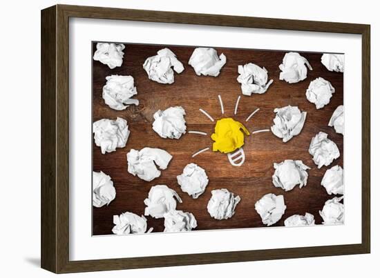 Light Bulb Symbol on Desk with Many Paper Balls-Stockphoto-Graf-Framed Art Print