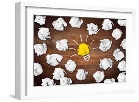 Light Bulb Symbol on Desk with Many Paper Balls-Stockphoto-Graf-Framed Art Print