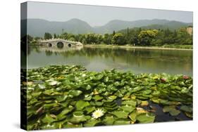 Lily Pads and a Arched Stone Bridge in Beijing Botanical Gardens, Beijing, China, Asia-Christian Kober-Stretched Canvas