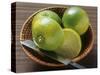 Limes, Two Whole and One Halved in a Small Basket-Eising Studio - Food Photo and Video-Stretched Canvas